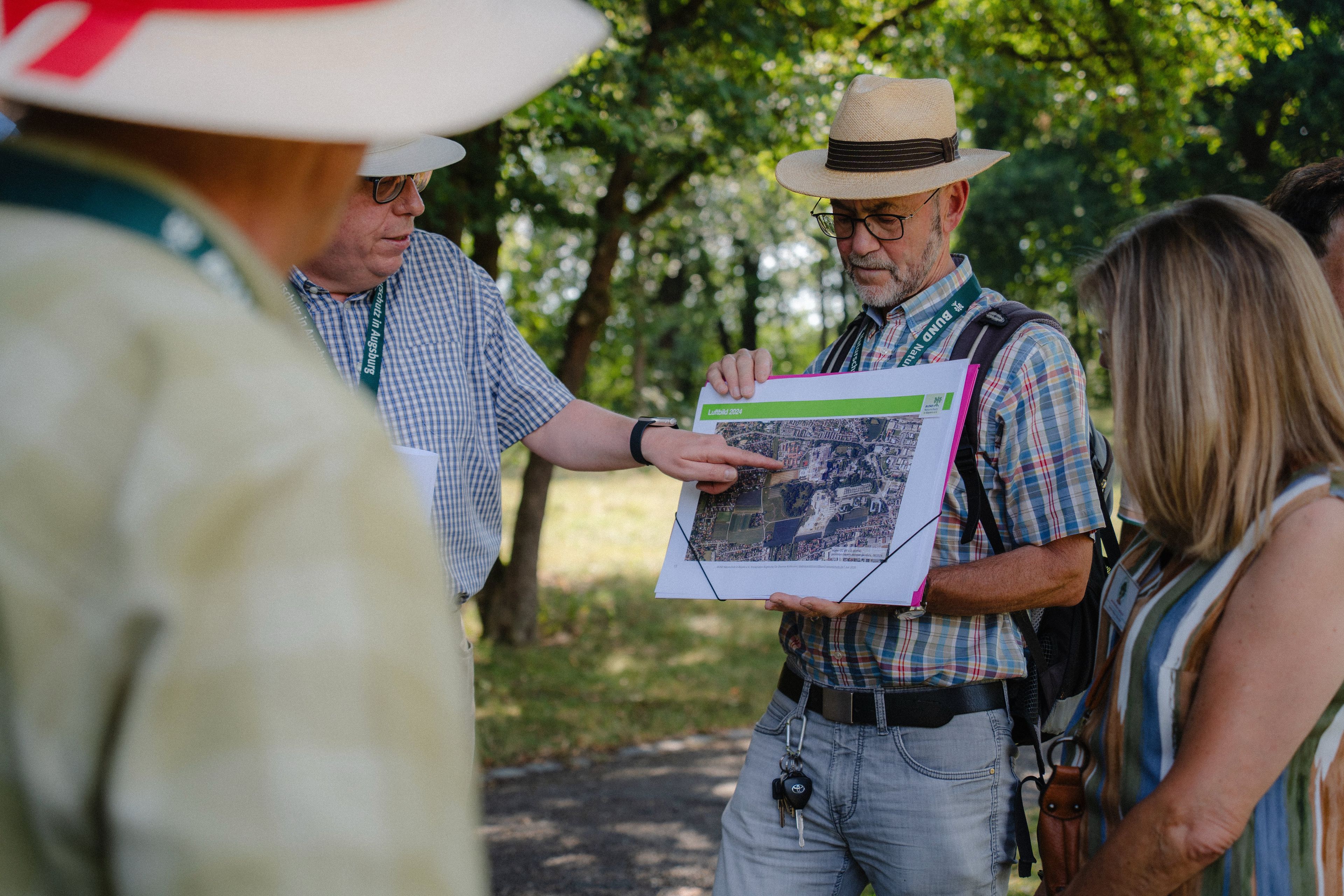 Dr. Dietmar Kuhlmann vom BUND Naturschutz Kreisgruppe Augsburg erklärt die Standortalternativen (Foto: Fisima Tente Fotografie, 29.07.2026)